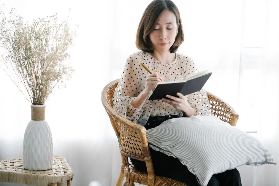 Wanita sedang menulis agenda di buku catatan dengan latar jendela